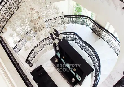 Luxurious grand staircase with elegant chandelier in opulent home