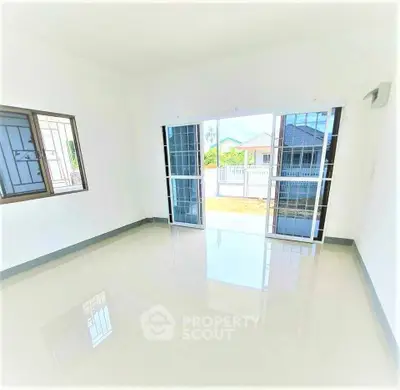 Spacious bright room with large windows and sliding doors opening to a garden view, perfect for modern living.