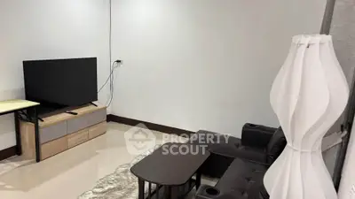 Modern living room with sleek furniture and large TV, perfect for relaxation and entertainment.