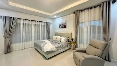 Spacious modern bedroom with elegant decor and large windows.