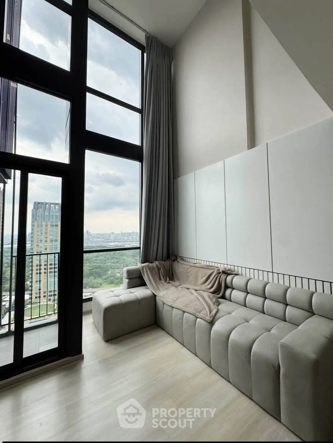 Stunning modern living room with floor-to-ceiling windows and breathtaking city view.