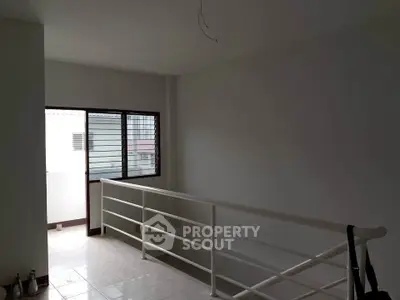 Spacious interior with modern railing and natural light, ideal for creative design opportunities.