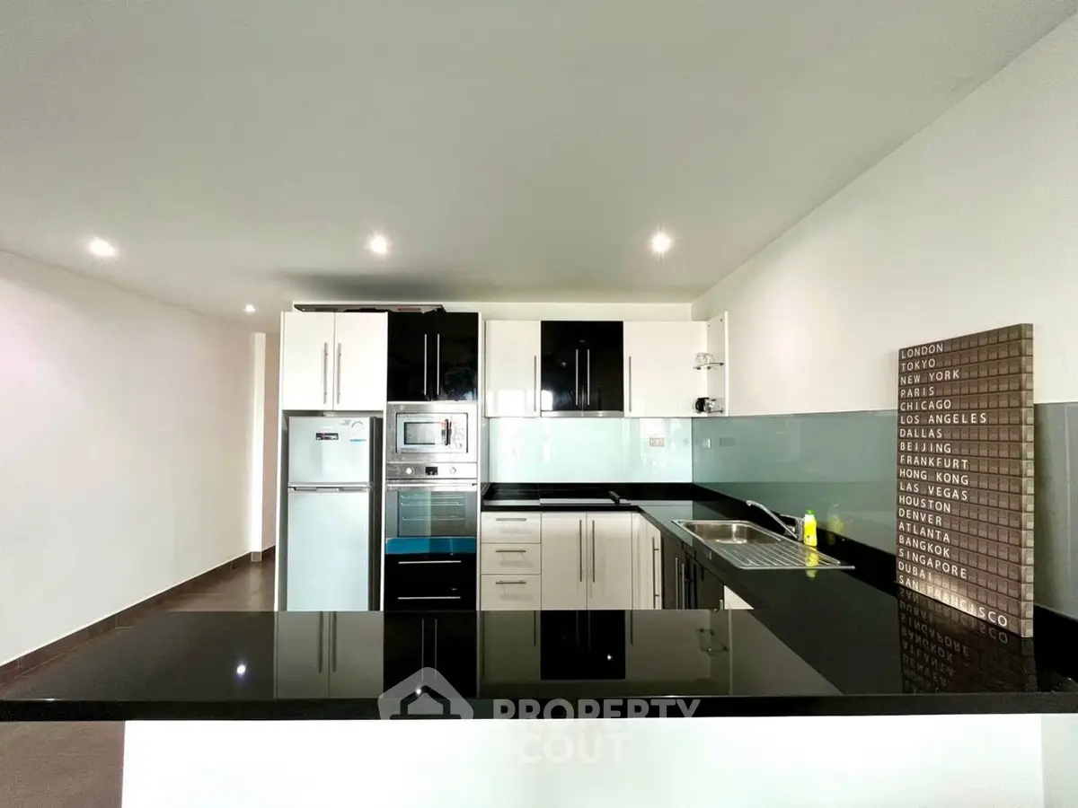 Modern kitchen with sleek black countertops and stainless steel appliances