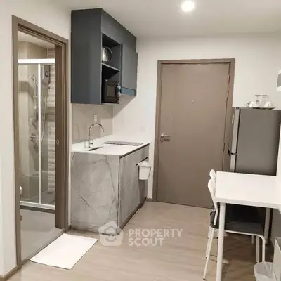 Modern compact kitchen with sleek design and integrated appliances in a cozy apartment.