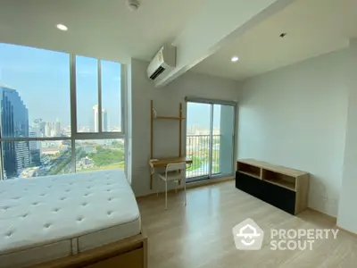 Modern bedroom with city view and balcony access in high-rise apartment