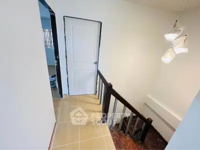 Bright stairway with modern lighting and wooden railing in a contemporary home.