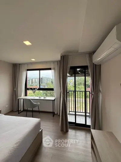 Modern bedroom with balcony view and natural light