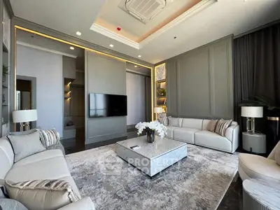 Luxurious living room with elegant decor and modern furniture, featuring a large TV and stylish lighting.