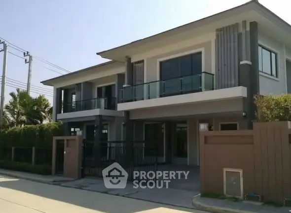 Modern two-story house with sleek design and spacious balcony in a serene neighborhood.