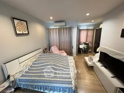 Spacious bedroom with modern decor and natural light, featuring a large bed and stylish furnishings.