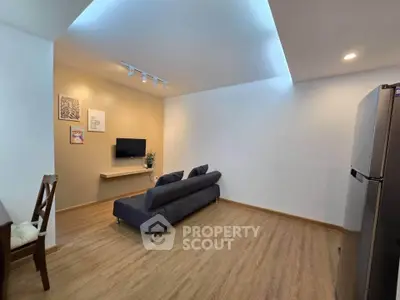 Modern living room with sleek design and cozy ambiance, featuring a stylish sofa and wall-mounted TV.