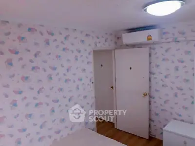 Cozy bedroom with whimsical wallpaper design, built-in closet, and modern air conditioning unit, perfect for comfortable living.