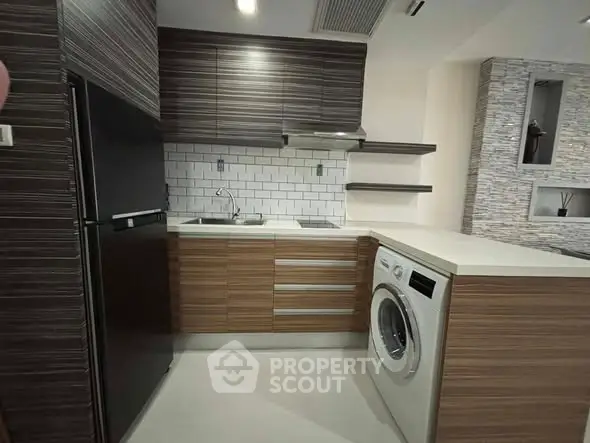 Modern kitchen with sleek cabinetry and built-in washing machine