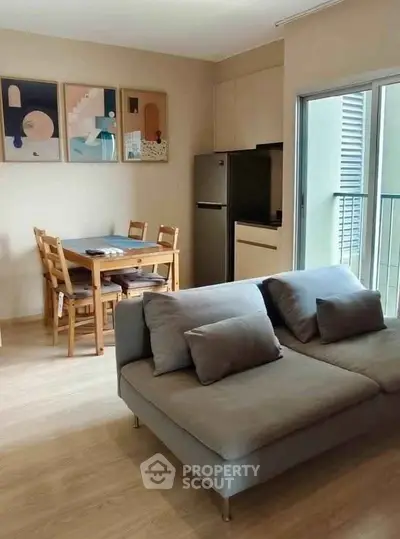 Modern living room with cozy sofa, dining area, and balcony access in stylish apartment.