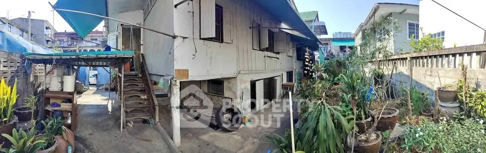 Charming rustic exterior of a traditional home with lush garden and outdoor seating area.