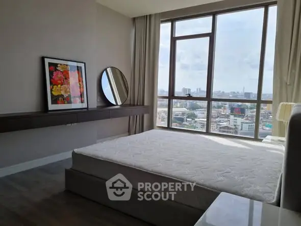 Spacious bedroom with city view and modern decor in high-rise apartment.