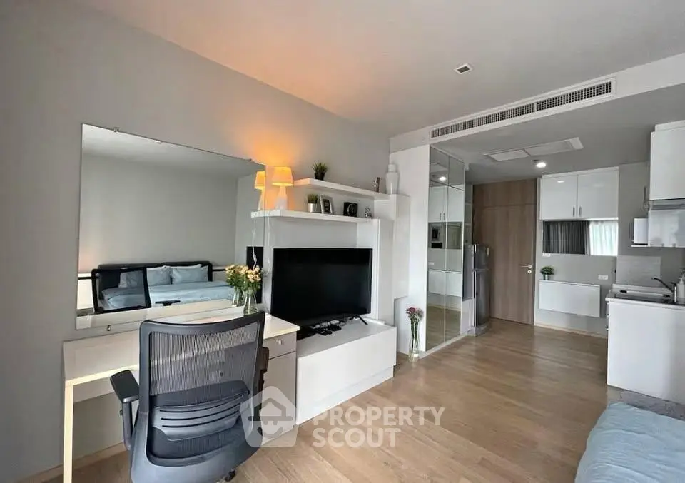 Modern studio apartment with open layout, featuring sleek kitchen and cozy living area.