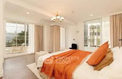 Luxurious bedroom with large windows and elegant decor in a modern apartment.