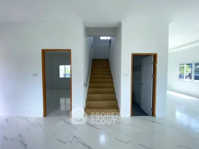 Spacious modern interior with marble flooring and central staircase