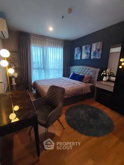 Elegant bedroom with modern decor and large window for natural light.