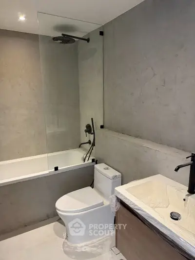 Modern bathroom with sleek design, featuring a bathtub and contemporary fixtures.