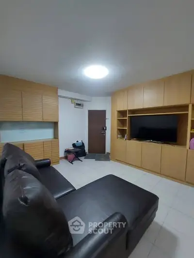 Cozy living room with modern furniture and built-in wooden cabinets, perfect for relaxation and entertainment.
