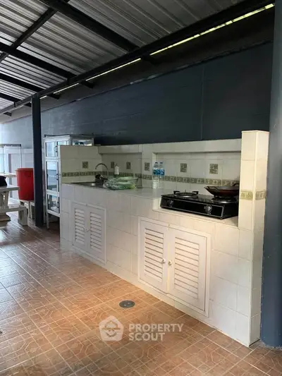 Charming outdoor kitchen with gas stove and ample counter space, perfect for alfresco dining and entertaining.