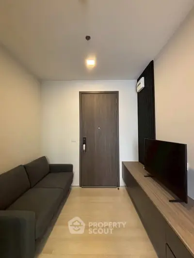 Modern living room with sleek furniture and minimalist design, featuring a comfortable sofa and flat-screen TV.