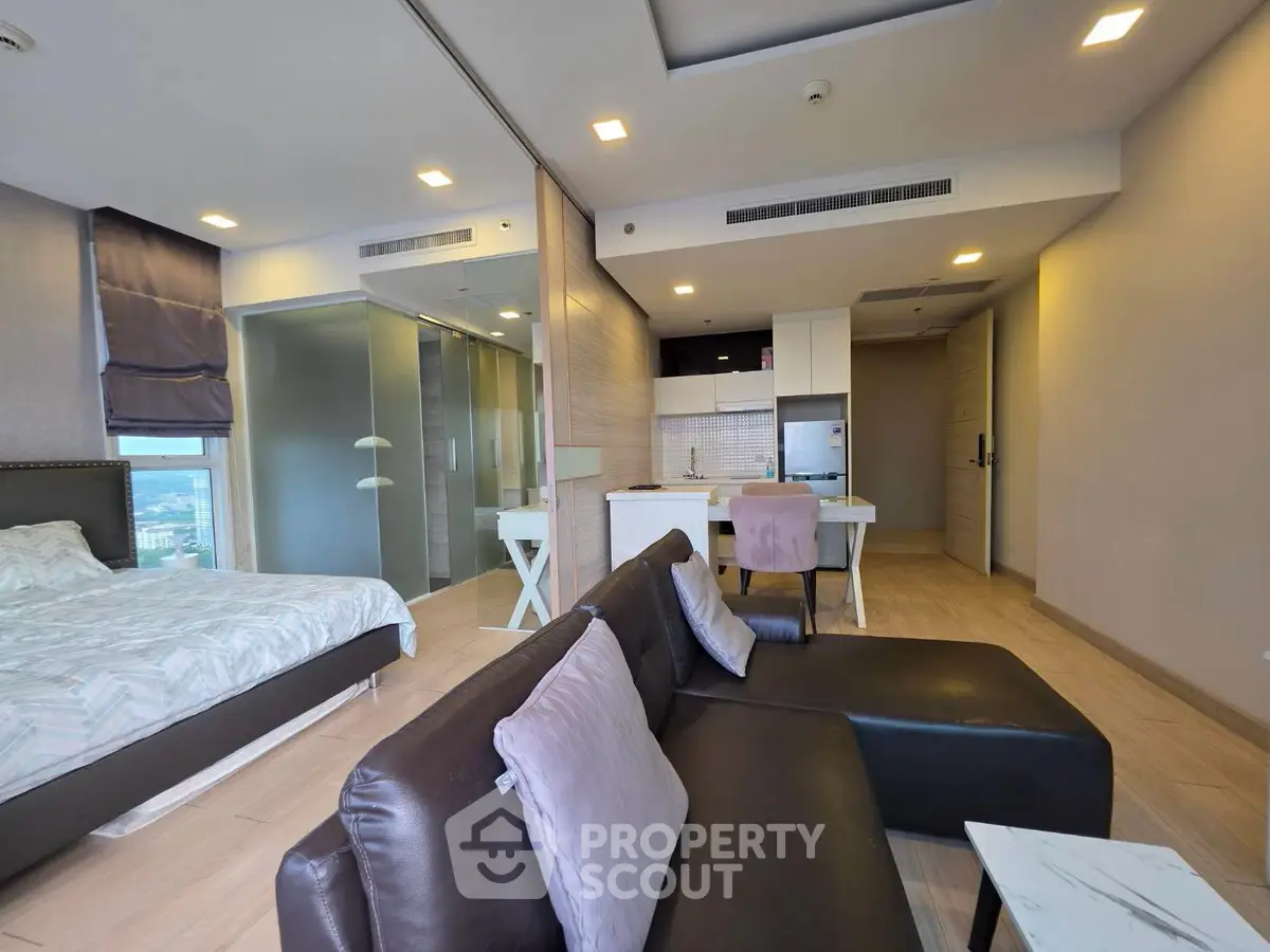 Modern open-plan studio apartment with stylish furnishings and city view