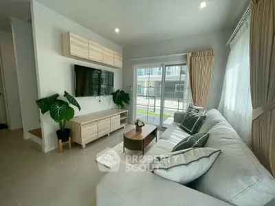 Modern living room with stylish decor and large windows offering natural light.