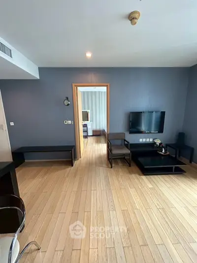 Modern living room with wooden flooring and wall-mounted TV
