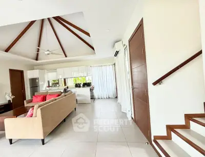 Spacious open-plan living room with modern kitchen and high ceilings in a stylish home.