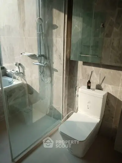 Modern bathroom with sleek shower and toilet in elegant marble design