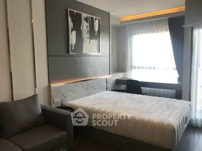 Modern bedroom with stylish decor and natural light, featuring a comfortable bed and cozy seating area.
