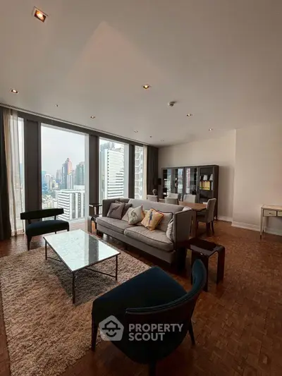 Spacious living room with city view and modern furniture in high-rise apartment.