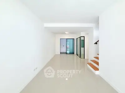 Spacious modern living room with sleek tile flooring and glass doors