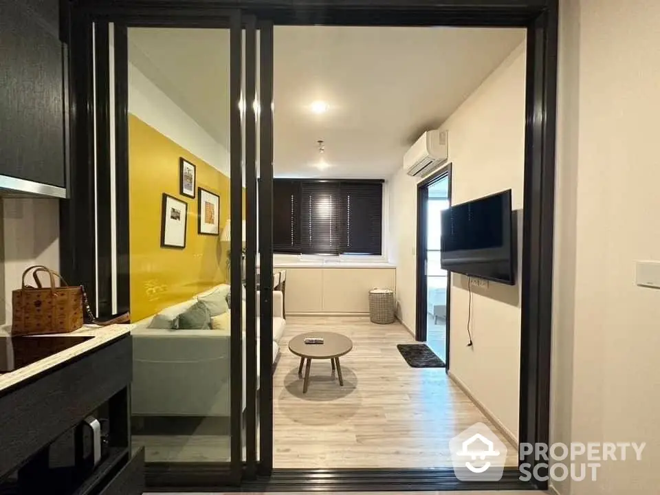 Modern apartment interior with a cozy living room, sleek kitchen, and vibrant yellow accent wall, perfect for urban living.