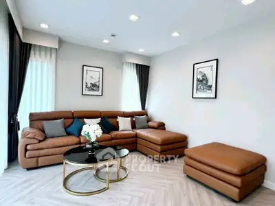 Luxurious modern living room with brown leather sectional sofa and stylish decor.