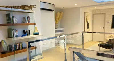 Modern living room with glass railing, stylish decor, and open layout for luxurious living.