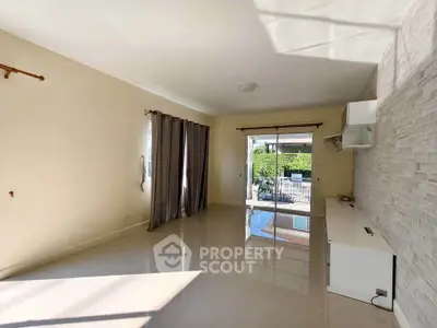 Spacious living room with large windows and modern tile flooring