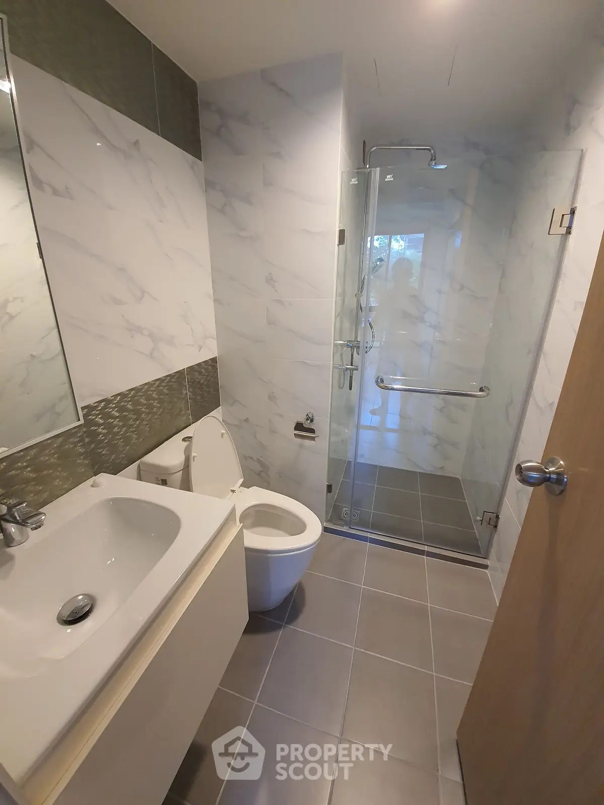 Modern bathroom with sleek design, featuring a glass shower and elegant fixtures.