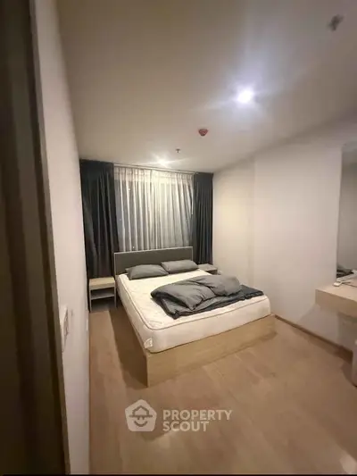 Modern bedroom with cozy lighting and minimalist decor in a stylish apartment.