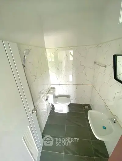 Compact bathroom with modern fixtures and marble wall tiles