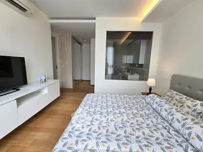 Spacious bedroom with modern decor and large window for natural light