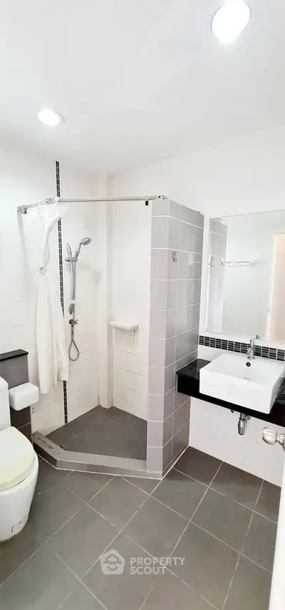 Modern bathroom with sleek shower and stylish sink in contemporary home.