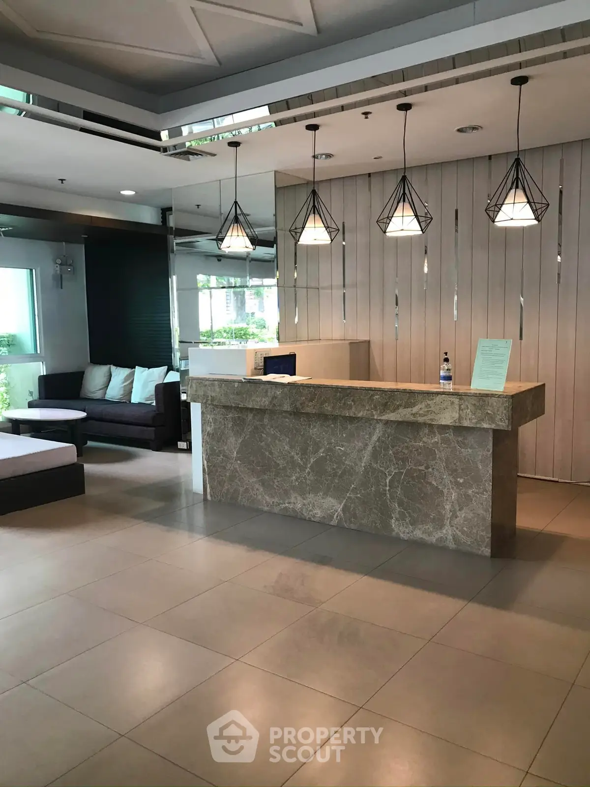 Modern lobby with stylish lighting and marble reception desk in luxury building.
