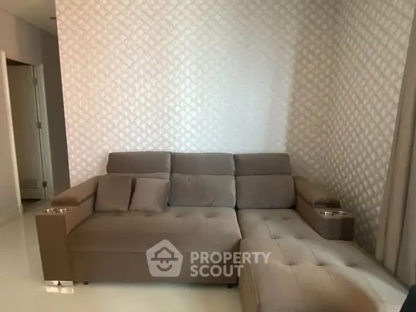 Modern living room with stylish sectional sofa and textured wall design.