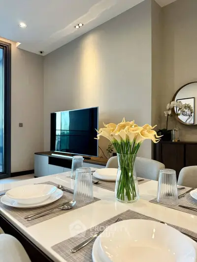 Elegant dining area with modern decor and TV, perfect for stylish living.