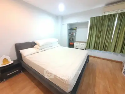 Spacious bedroom with wooden flooring and modern furnishings