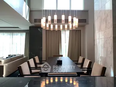 Luxurious dining area with modern chandelier and elegant seating in a spacious open-plan living space.